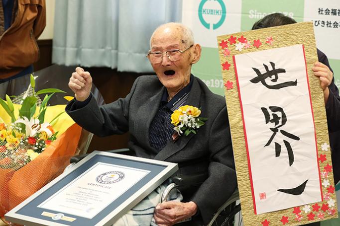 Japanese Chitetsu Watanabe, aged 112, poses next to the calligraphy reading in Japanese 'World Number One' after he was awarded as the world's oldest living male (AFP Photo/STR)