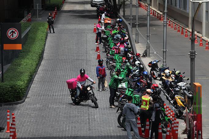 Food delivery riders park near a mall in Bangkok to pick up orders on May 10. (Photo by Apichart Jinakul) 