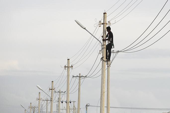 လျှပ်စစ်ကျွမ်းကျင်လုပ်သားတစ်ဦးက လျှပ်စစ်ကြိုးများသွယ်တန်းနေသည်ကို ၂၀၁၆ ခုနှစ်၊ နိုဝင်ဘာလ ၁၀ ရက်က နေပြည်တော်တွင် တွေ့ရစဉ်။ ဓာတ်ပုံ-ဟိန်းထက်/EPA
