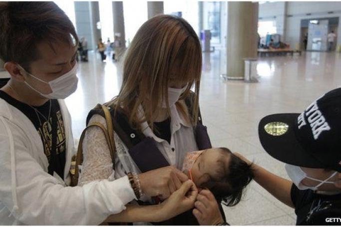 ရောဂါကူးစက်မည်ကို စိုးရိမ်သော ပြည်သူများ နှာခေါင်းစည်းများ တပ်၍ သွားလာနေကြစဉ်။ ဓာတ်ပုံ- GettyImage