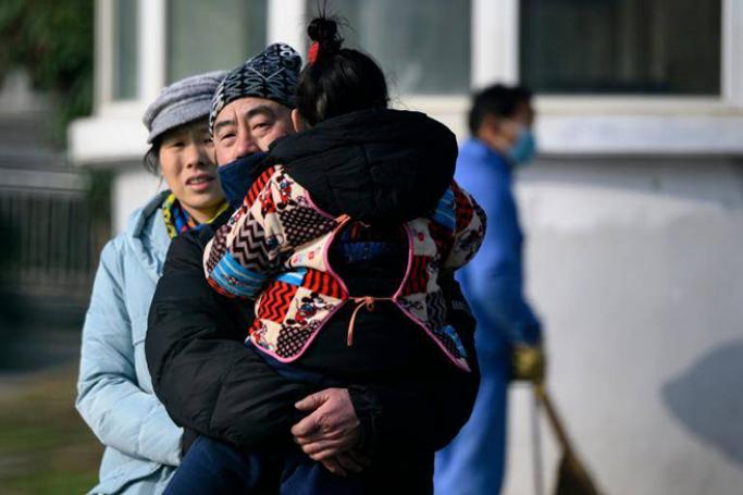 A man holding her daughter leaves the Wuhan Medical Treatment Centre in Hubei, China. The World Health Organisation confirmed on Monday (Jan 13) the first case in Thailand of a new virus from the same family as SARS that is behind a Chinese pneumonia outbreak. - AFP