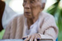An elderly voter is seen with her ink-stained finger outside a polling centre in Mandalay on November 8, 2015. Photo: AFP