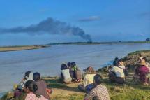 ပုံအညွှန်း ရွာမီးရှို့ ခံနေရသည်ကို အဝေးမှကြည့်နေရသည့် ရေလယ်ကျွန်းဒေသခံပြည်သူများ